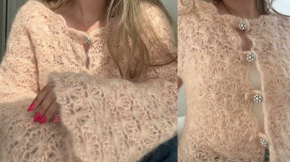 (Foto: Kreative Ideer/ Aurora Lange) En kvinne sitter på en lys sofa iført en pudderrosa mohaircardigan med florlett struktur og store krystallknapper, med ermene dratt delvis ned over hendene og blå jeans.