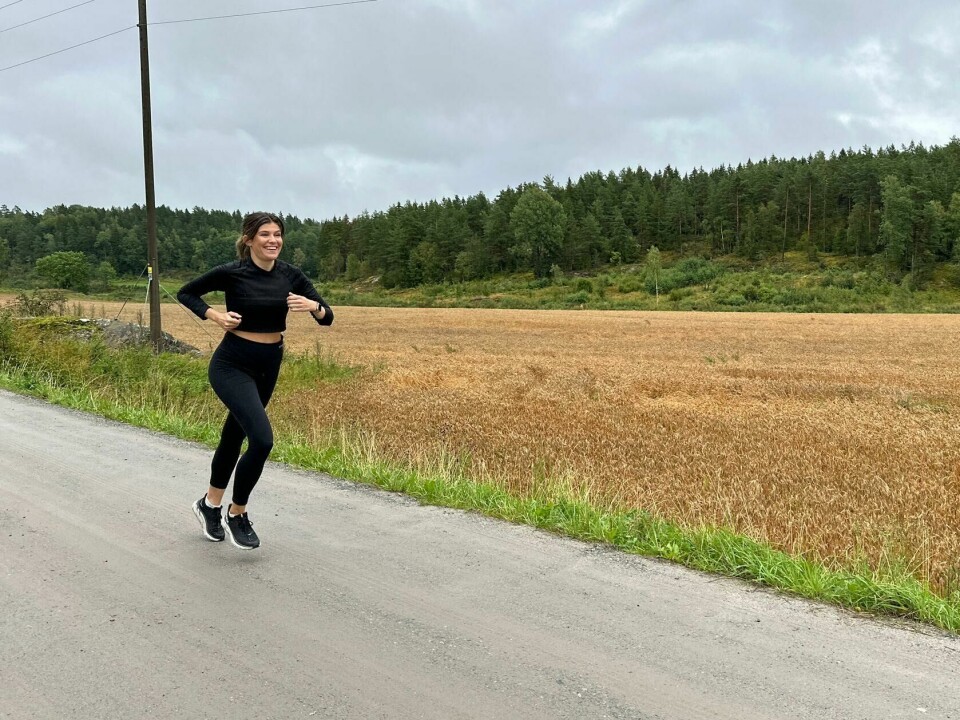 Elander forteller at generelt så vil 3-5 ganger i uka med styrke holde og da er 5 dager maks og ikke noe alle trenger. Han legger også til at man ikke må glemme viktigheten av litt daglig mosjon og forteller hvor enkelt det kan gjøres. (Foto: Mari-Ann Greiner Green) En kvinne løper langs en grusvei ved siden av et modent kornfelt. Hun er kledd i svart treningstøy og ser smilende og energisk ut. I bakgrunnen er det tett skog og overskyet himmel, noe som gir en rolig, naturlig stemning. Landskapet er landlig og åpent, og bildet formidler både treningsglede og frihet i naturen. Styrketrening eller cardio for en strammere og slankere kropp, og flest mulig treningstimer for best resultat? PT-en avkrefter treningsmyter.