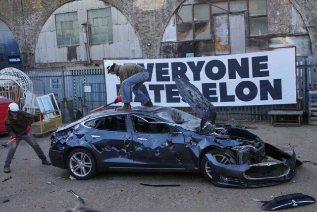 Elon Musks inntreden i politikken har ikke vært positivt for Teslas omdømme. Her ødelegges en Tesla, som skulle skrotes, under et arrangement arrangert i protest mot Elon Musk av gruppen «Everyone Hates Elon» i London 10. april i år.