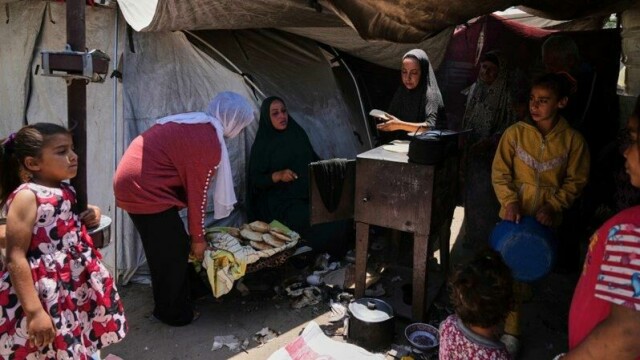 Fordrevne palestinere baker brød i en teltleir i Gaza by onsdag. Behovet for mat og nødhjelp er stort, men til nå har svært lite av de få lastebilene med nødhjelp som har kommet inn blitt distribuert.