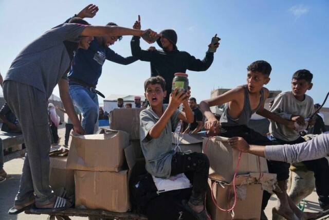 Palestinere viser fram innholdet i matkasser i Rafah tirsdag.