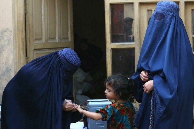 En liten jente i Kabul får tegnet et merke på fingeren for å vise at hun har tatt poliovaksinen. WHO advarer om at USAs store bistandskutt kan få konsekvenser for vaksineringen i Afghanistan.