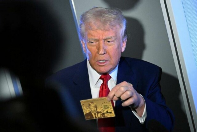 President Donald Trump holder opp gullkortet på fem millioner dollar mens han snakker med journalister om bord på Air Force One, på vei til Miami, torsdag 3. april 2025. (Pool via AP)