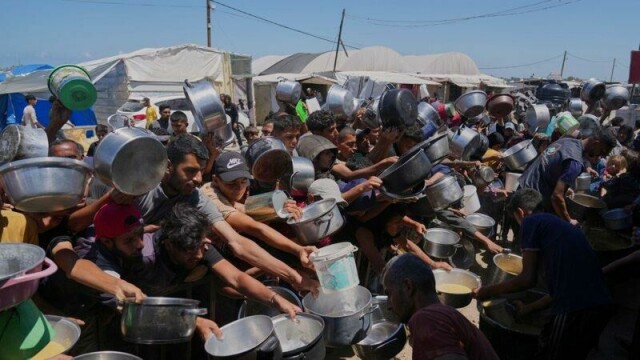 Palestinere står i kø for å få utdelt mat på et felleskjøkken i Khan Younis, sør på Gazastripen, mandag.