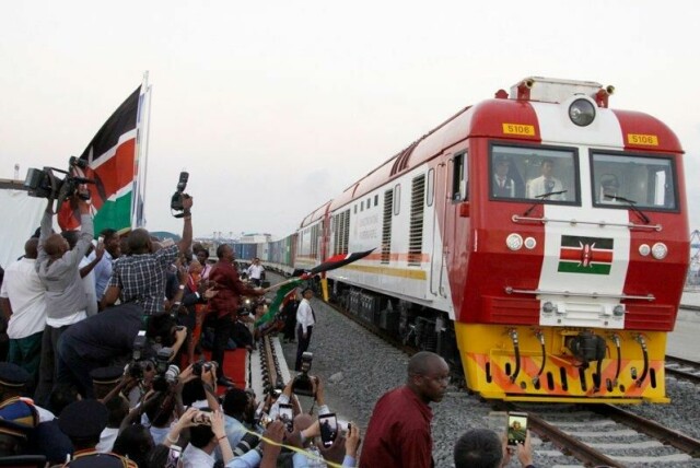 Et tog fra det kenyanske nettverket SGR kjører ut fra et havneanlegg fullastet med konteinere. Kenyas president åpnet den kinesiskfinansierte jernbanen i 2017. Den er et av de største infrastrukturprosjektene i landet siden det fikk uavhengighet. Mens Kina satser stort på slike prosjekter, trekker USA seg nå ut.