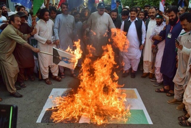 Pakistanere brenner en plakat med et indisk flagg og bilde av Indias statsminister Narendra Modi.