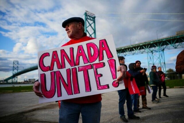 En tilhenger av det liberale partiet oppfordrer canadierne til å stå samlet, trolig mot USA på den andre siden av Ambassador-broen i Windsor.