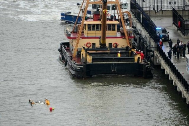 Et kranfartøy kommer til åstedet der et helikopter styrtet i Hudson-elva i New York.