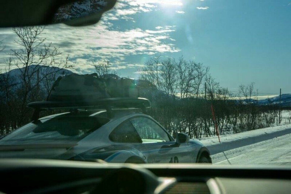 Ekspedisjonssjefens Porsche 911 Dakar brøler forbi og virvler opp et langt slør av hvit snø i dragsuget. Ekspedisjonssjefens Porsche 911 Dakar brøler forbi og virvler opp et langt slør av hvit snø i dragsuget. Foto: Ragnvald Johansen / Finansavisen