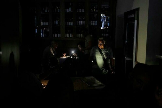 Folk spiser inne i en mørklagt restaurant i Madrid under det store strømbruddet i Spania.