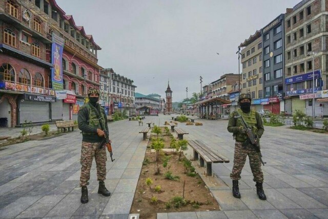 Indiske styrker holder vakt i Srinagar, hovedstad i den indiskkontrollerte delen av Kashmir, lørdag morgen etter at det ble hørt kraftige eksplosjoner i byen.