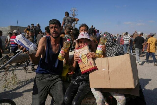 Palestinere viser fram pakkene med mat de har fått utdelt.
