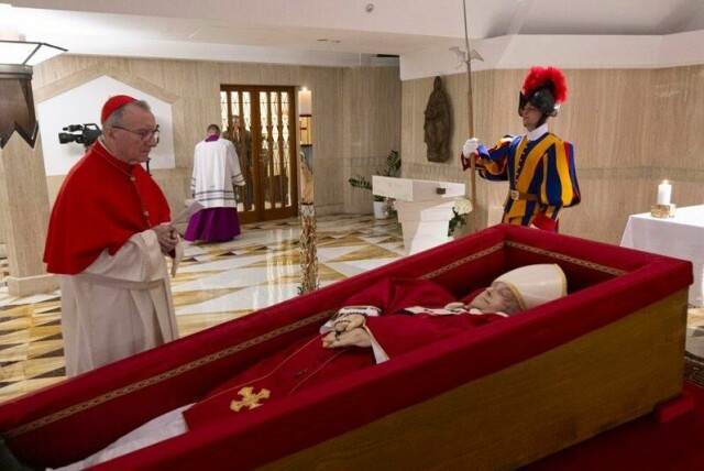 Pave Frans ligger i åpen kiste i Vatikanet. Ved siden av står Vatikanets nummer to, kardinal Pietro Parolin, og ber.