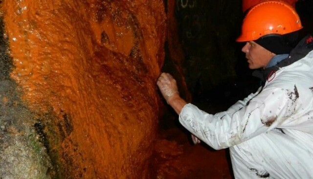Biofilm av bakterier ødelegger betongen i den dype veitunnelen under Oslofjorden, som vist her. Tunnelen går mellom Drøbak og Hurum. Rødfargen har bakteriene fått fra rustende armering inne i sprøytebetongen.