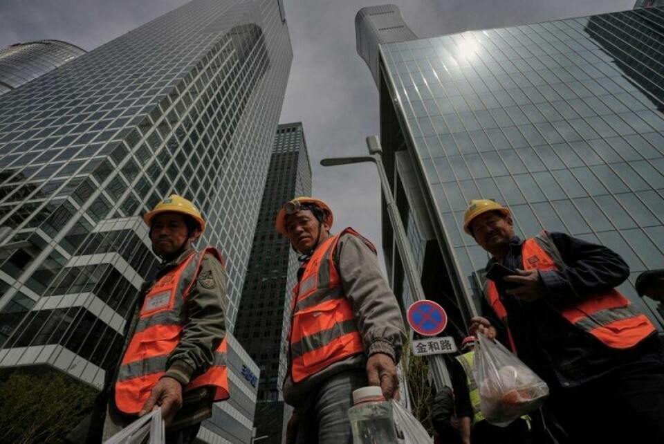 Bygningsarbeidere har kjøpt lunsj mens de er på jobb i et finansstrøk i Beijing. Bygningsarbeidere har kjøpt lunsj mens de er på jobb i et finansstrøk i Beijing. Foto: Andy Wong / AP / NTB