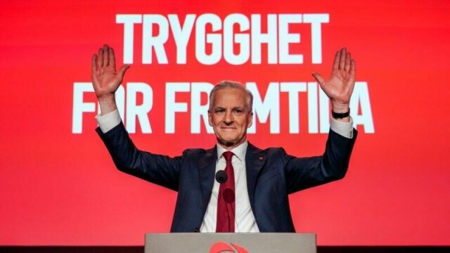 Statsminister Jonas Gahr Støre taler foran Arbeiderpartiet landsmøte. Bak han står det nye slagordet.