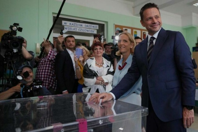 Presidentkandidat Rafal Trzaskowski og hans kone Malgorzata Trzaskowska i valglokalene søndag formiddag.