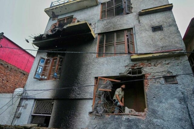 En beboer undersøker ødeleggelser på huset sitt etter et pakistansk artilleriangrep i Poonch i den indiskkontrollerte delen av Kashmir.