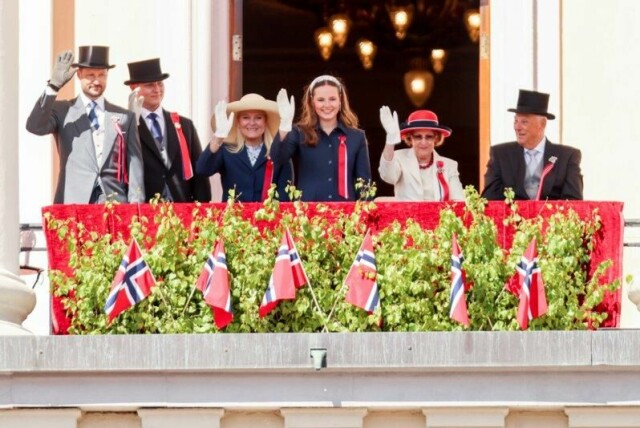 Kongefamilien hilser barnetoget i Oslo fra Slottsbalkongen på Slottet. Fra venstre: kronprins Haakon, prins Sverre Magnus, kronprinsesse Mette-Marit, prinsesse Ingrid Alexandra, dronning Sonja og kong Harald.