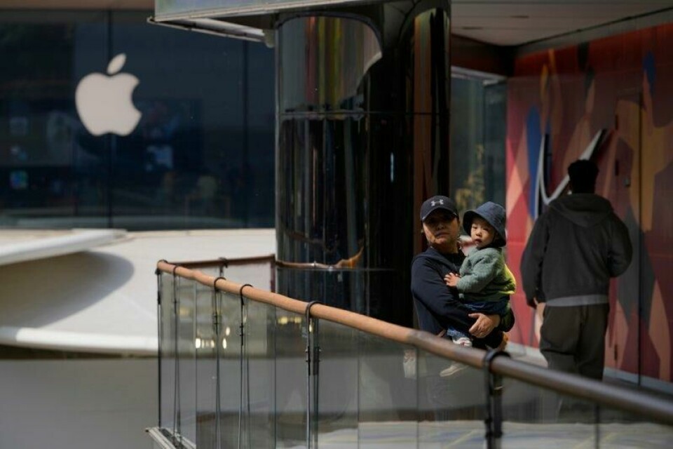 En kvinne og et lite barn i nærheten av en Apple-butikk og en Nike-butikk i Beijing. En kvinne og et lite barn i nærheten av en Apple-butikk og en Nike-butikk i Beijing. Foto: Ng Han Guan / AP / NTB