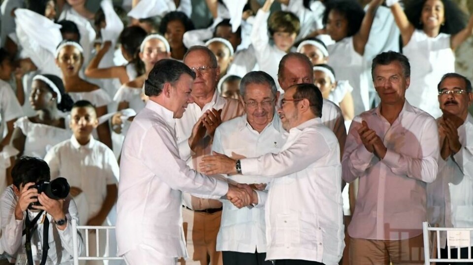 HISTORISK HÅNDTRYKK: Colombias president Juan Manuel Santos (til venstre) og leder av geriljabevegelsen FARC, Timoleon «Timosjenko» etter at de undertegnet fredsavtalen seg i mellom i Cartagena 26. september. Utenriksminister Børge Brende var blant de tilstedeværende.