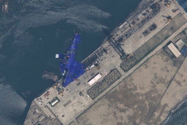 En blå presenning ligger over krigsskipet, en 5000 tonns jager, etter den feilslåtte sjøsettingen. Satellittfoto: Airbus DS / AP / NTB