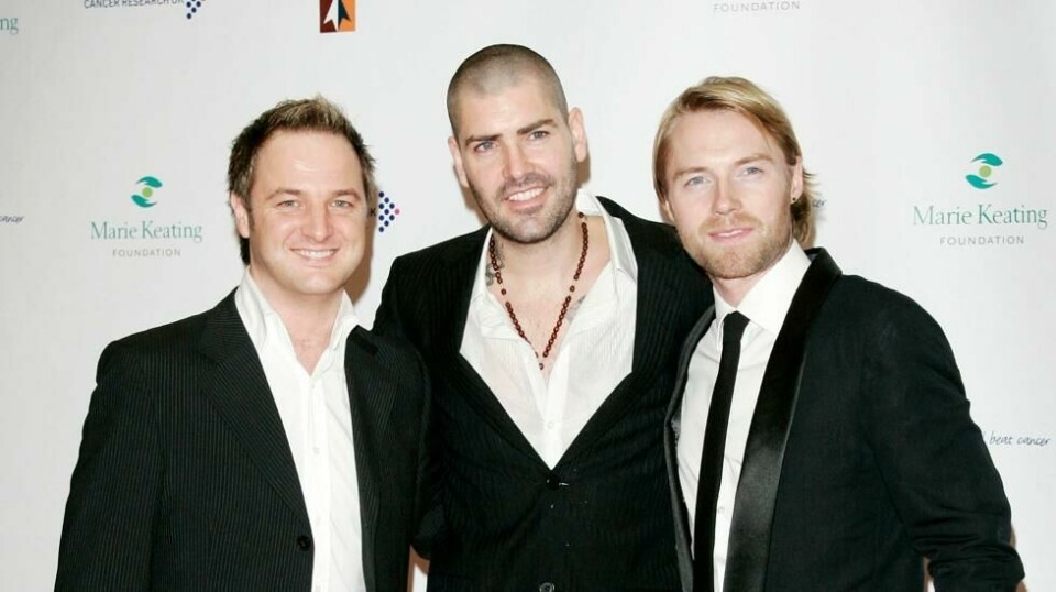 Shane Lynch (midten) gjorde suksess på 90- og starten av 00-tallet med gruppen Boyzone sammen med blant annet Mikey Graham og Ronan Keating. Nå melder han at han har gått fra kona og barn, og han gir skylden til corona. Bildet er tatt i 2007. Foto: AP Photo/Sang Tan
