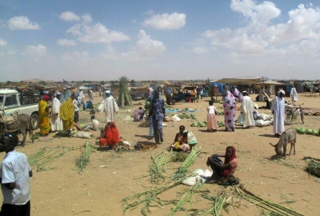 Folk klargjør avlinger av sukkerrør og vannmeloner for salg i Abu Shouk-flyktningleiren i utkanten av El Fasher i Nord-Darfur i Sudan. Arkivfoto: AP / NTB