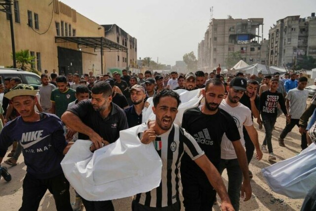 Palestinere bærer slektninger som er drept i israelske angrep. Bildet er tatt søndag under en begravelsesseremoni i Khan Younis, sør på Gazastripen.