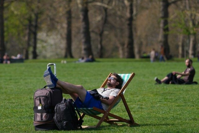 En mann nøt sola en uvanlig varm dag i London i starten av april.