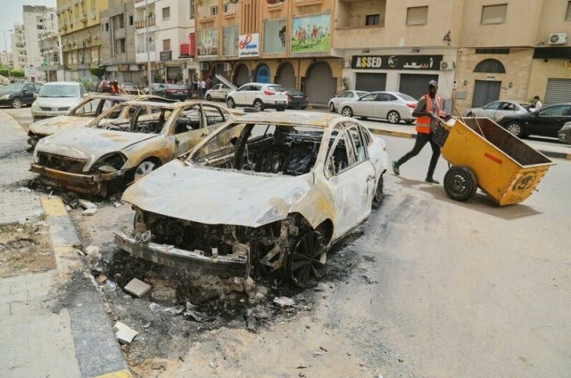 Utbrente biler står igjen etter sammenstøt mellom mlitsgrupper i Tripoli i orrige uke.