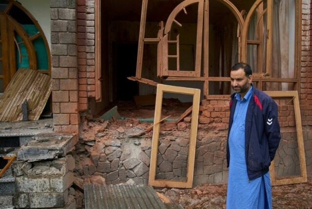 En mann i landsbyen Gingal i Uri, i den indiskkontrollerte delen av Kashmir, står utenfor det ødelagte huset sitt etter beskyting fra Pakistan.