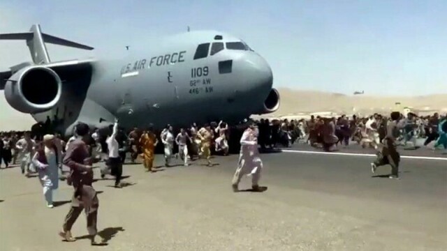 Hundrevis av mennesker løper på rullebanen i Kabul mens et amerikansk transportfly er i ferd med å ta av 16. august.