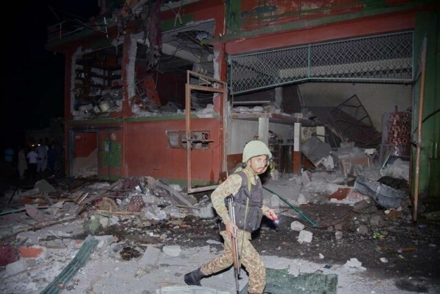 En pakistansk soldat foran en bygning som ble truffet i det indiske angrepet mot pakistanskkontrollert Kashmir og Pakistan natt til onsdag. Bildet er fra Muzaffarabad, hovedstaden i pakistansk Kashmir.
