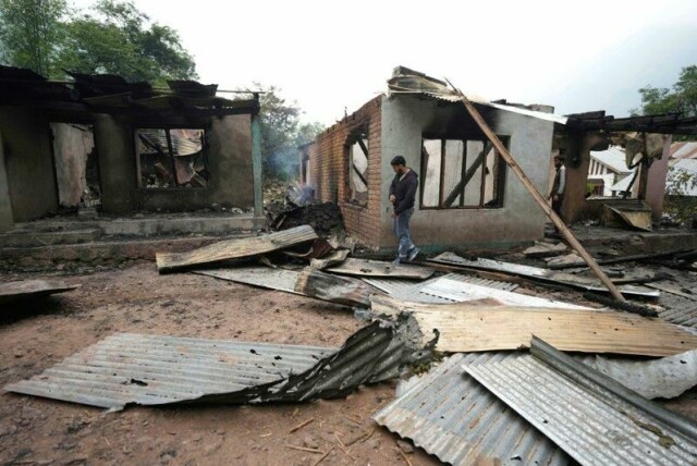 En mann går utenfor et hus skadet av pakistansk artilleribeskytning i landsbyen Salamabad i Uri i det indiskkontrollerte Kashmir.