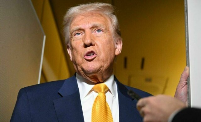 President Donald Trump om bord på presidentflyet på vei til Miami lørdag.
