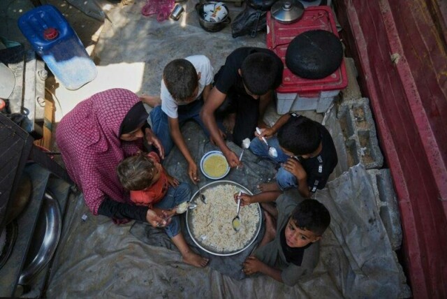 Tahreer Abu Jazar (36) deler et id-al-adha-måltid bestående av linsesuppe og ris med barna sine inne i en teltleir i Mawasi sør i Gaza fredag.