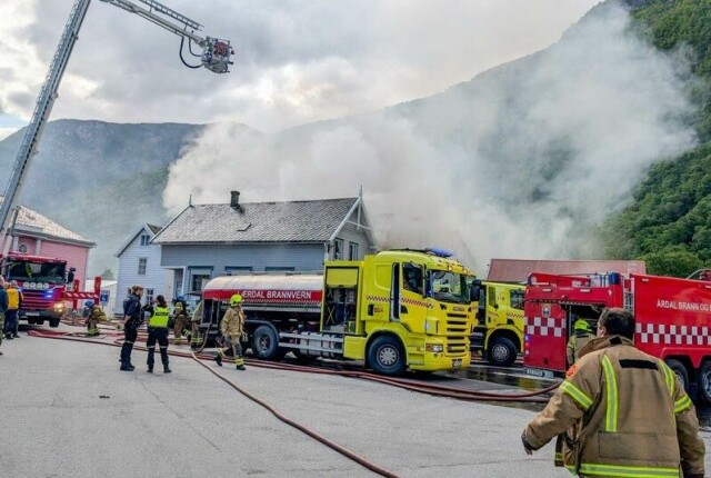 Det brenner i en eldre trebygning i Lærdal sentrum lørdag morgen. Brannen har spredt seg til en nabobygning og politiet evakuerer nærliggende bygninger.