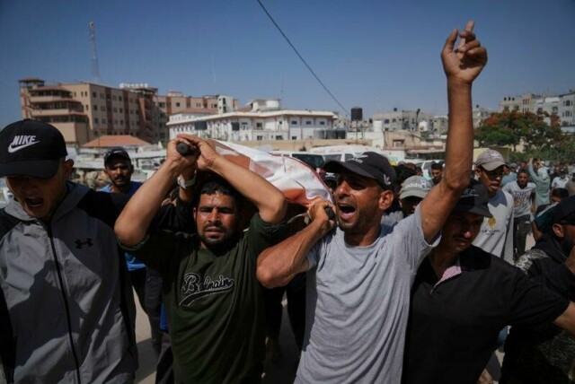 Palestinere bærer Ahmed Abu Hilal, en av dem som søndag ble drept på vei til en matsentral, til graven i Khan Younis.