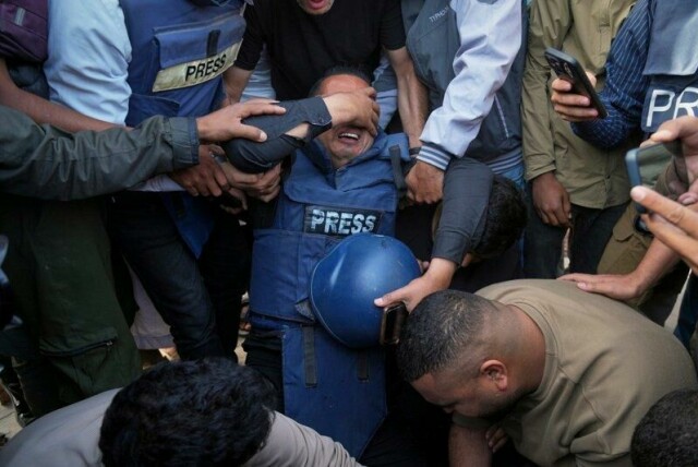 Bildet viser flere sørgende ved liket av en palestinsk journalist som ble drept i et israelsk angrep mot Nasser-sykehuset. Bildet er tatt i Khan Younis, sør på Gazastripen, 13. mai.