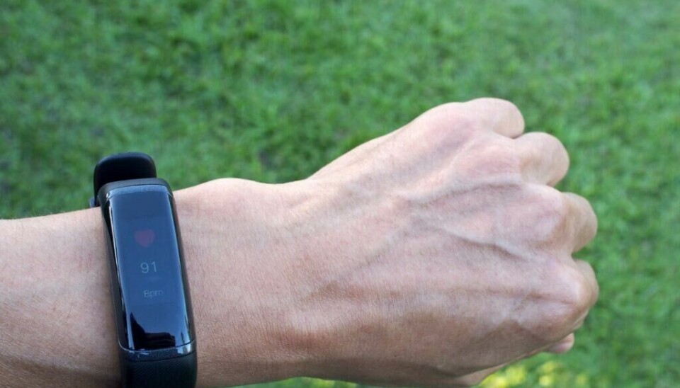 I starten var en aktivitetsklokke helt enkle armbånd som målte kalorier, distanse og puls, og som ikke hadde så voldsomt med treningsfunksjoner. Nå kan selv de enkleste aktivitetsmålerne måle masse treningsfunksjoner, og de fleste har også innebygd GPS. (Foto: andy0man / Shutterstock / NTB) Bildet viser en håndleddet i nærbilde, der personen bærer en slank, sort aktivitetsklokke eller treningsarmbånd med rektangulær skjerm. Skjermen viser en pulsverdi på 91 bpm (slag per minutt) sammen med et rødt hjerteikon øverst. Klokken har et minimalistisk design uten fysiske knapper og med en blank skjermflate. Bakgrunnen er en grønn plen, noe uskarp, som indikerer at bildet er tatt utendørs i dagslys – sannsynligvis i en park eller hage.
Det er mye penger å spare i å velge riktig av en smartklokke, pulsklokke og aktivitetsklokke. Her er det mange gjør feil, og slik velger du riktig.