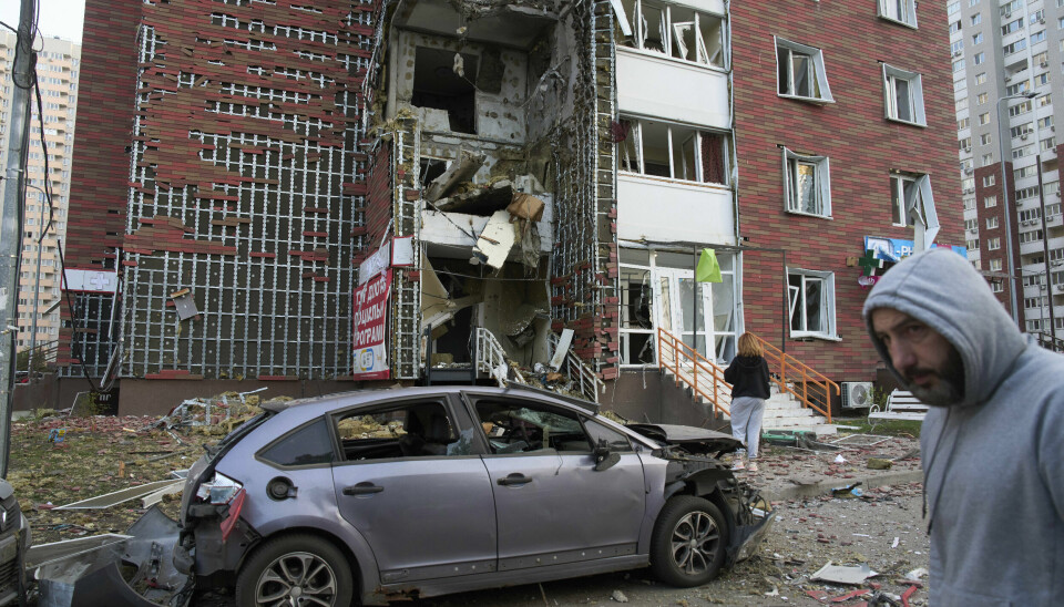 Ukrainere ser på en boligblokk i Kyiv som ble ødelagt i et russisk luftangrep tirsdag.
