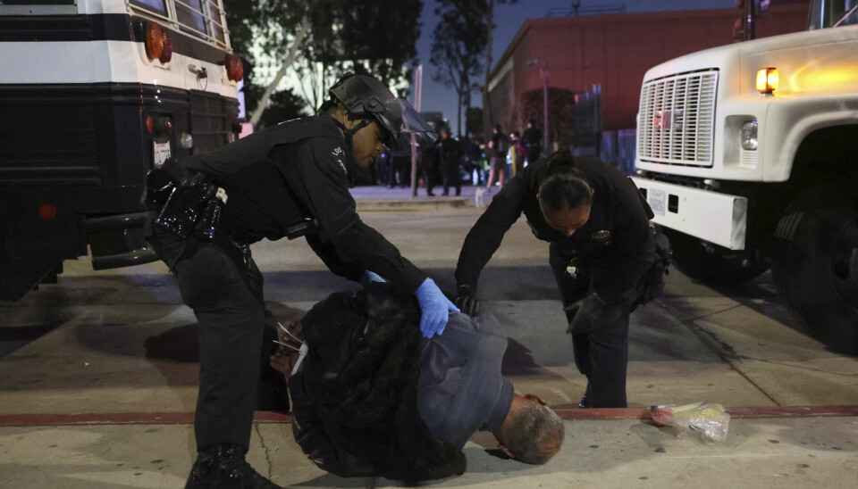 Nødetater undersøker en mann som er pågrepet i forbindelse med demonstrasjoner i Los Angeles.