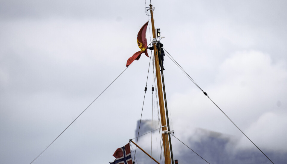 En person i masta på kongeskipet Norge etter at kongeflagget viklet seg inn.
