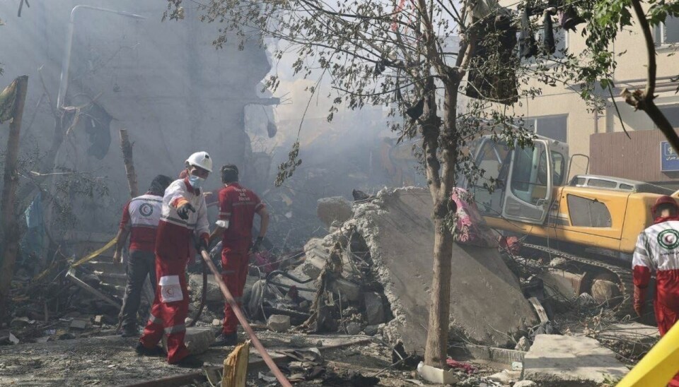 Redningsarbeidere i arbeid i Teheran fredag etter et israelsk luftangrep.