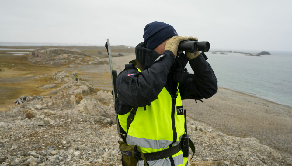 Bevæpnet personell fra Kystvakten holder kontroll over området hvor kong Harald og dronning Sonja skal på besøk på Svalbard.