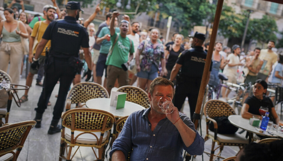 Noen turister forsøkte å nyte varmen på Mallorca søndag, mens lokale demonstrerte i bakgrunnen.