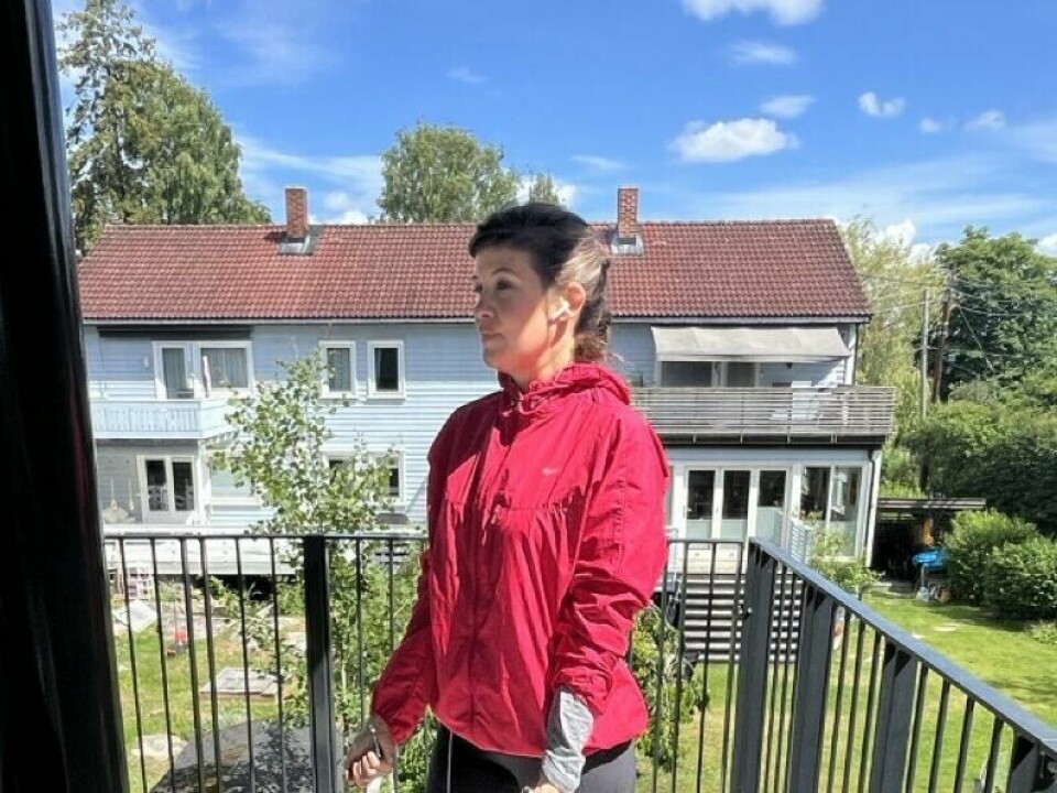 Bilde av en dame i rosa treningsjakke og svarte tights som står ute i en oppgang med en treningsmatte og i bakgrunnen er det grå rekkehus, frodig grønn plen og trær. Løpetreneren fortellerhvordan du kan trene opp bedre utholdenhet innen løping ved hjelp av intervaller, korte løpeturer eller langøkter.