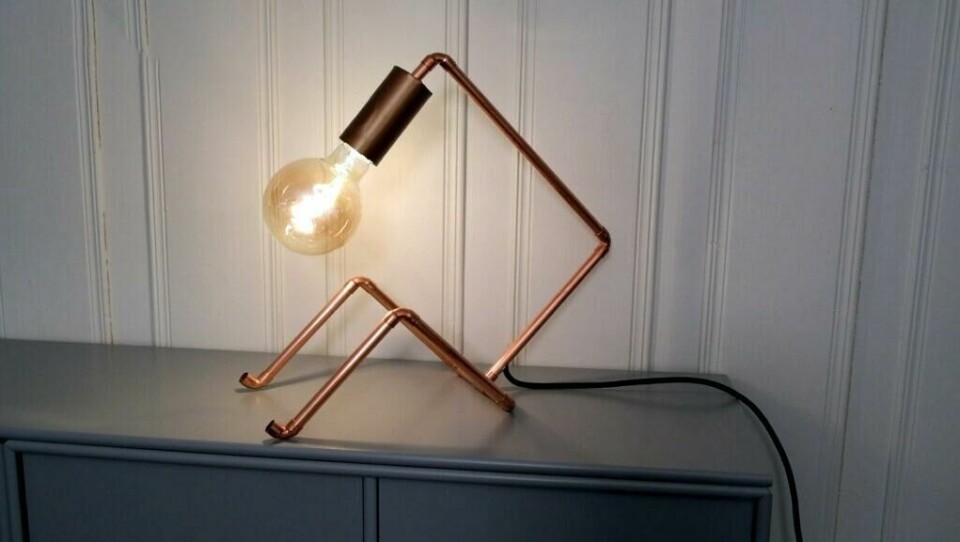 En søt lampe av kobberrør som ser ut som en sittende strek-figur. (Foto: Espen Skarphagen)