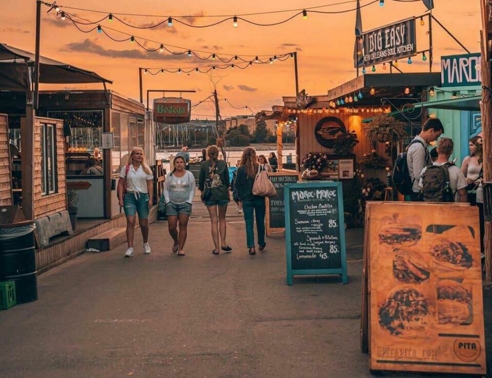 Reffen i København er et populært streefood markedet som ligger på Refshaleøen-øya. Besøker du den danske hovedstaden anbefaler vi å ta turen innom dette matmarkedet. (Foto: Reffen) Bildet viser et utendørs matmarked i København. Flere mennesker går langs en asfaltert vei omgitt av små matboder og kafeer på begge sider. Folk er kledd i sommerklær, og noen sitter og snakker ved bord. I bakgrunnen kan man skimte seilbåter fortøyd ved en brygge, noe som tyder på at markedet ligger i nærheten av vannet. Stemningen er avslappet og innbydende, med et varmt og gyllent lys som preger bildet. Her finner du tips til ni matmarkeder i populære europeiske storbyer som Paris, Berlin, Roma, Barcelona, København, Lisboa og London.